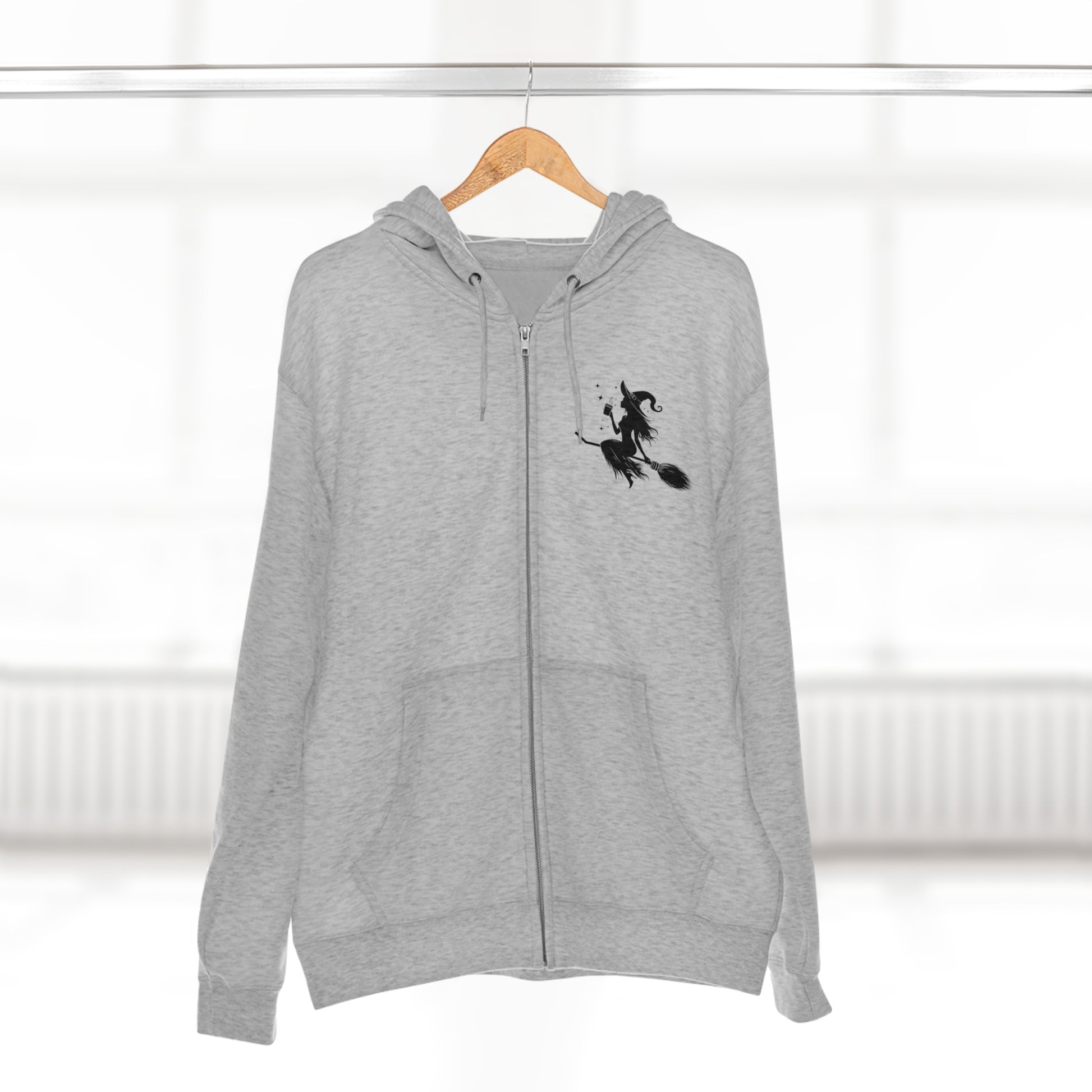 Hoodie: featuring a witch flying with a coffee cup, with a moon in the background. Gray color Hoodie with Black graphics on the front chest, and back.